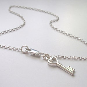 Peut inclure: Un bracelet de cheville en argent avec un pendentif en forme de clé de cœur.