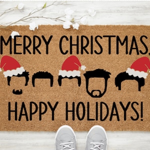 May include: A brown coir doormat with the text "Merry Christmas, Happy Holidays!" in black lettering. Five black silhouettes of people with brown hair are wearing red Santa hats.