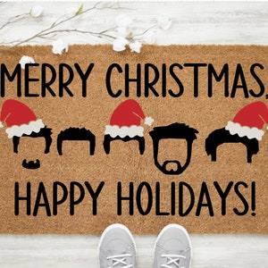 May include: A brown coir doormat with the text "Merry Christmas, Happy Holidays!" in black lettering. Five black silhouettes of people with brown hair are wearing red Santa hats.
