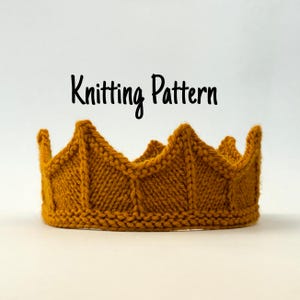 Op de afbeelding: Mosterdgele gebreide kroon met een zigzagpatroon. De kroon is handgemaakt en heeft een textuur. De tekst "Knitting Pattern" staat in zwart script boven de kroon.