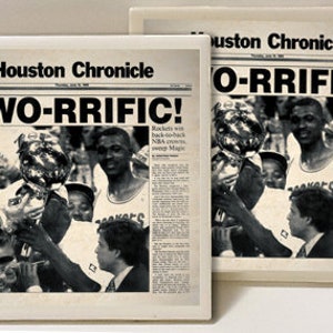 May include: Two newspaper clippings from the Houston Chronicle, both with the headline "TWO-RRIFIC!" and "O-RRIFIC!" The clippings feature photos of basketball players holding trophies.