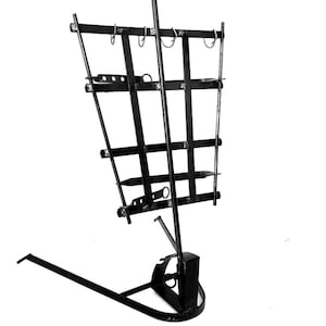 May include: Black metal fireplace tool holder with a handle and multiple hooks for hanging tools. The holder has a base with a curved shape.