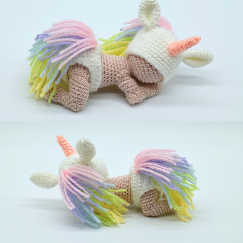 Puede incluir: Una mu&ntilde;eca de unicornio de crochet con un sombrero blanco con un cuerno rosa y una cola de hilo arco&iacute;ris. La mu&ntilde;eca est&aacute; tumbada de lado con la cabeza apoyada en el brazo.