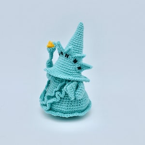 Puede incluir: Una estatua de crochet azul y amarilla de la Estatua de la Libertad. La estatua sostiene una antorcha en su mano derecha.