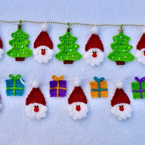 May include: A Christmas garland with crocheted ornaments. The garland features red Santa Claus figures, green Christmas trees, and blue, purple, and yellow gift boxes.
