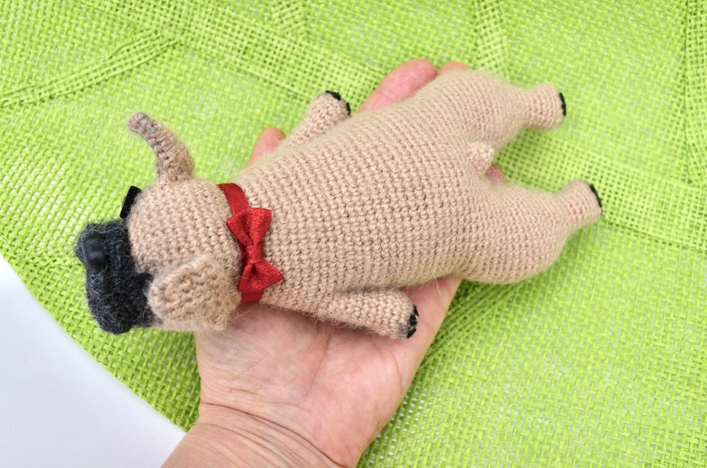 May include: A crocheted tan dog toy with black eyes and a red bow tie.