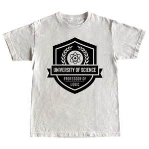 Puede incluir: Camiseta blanca con un gráfico en blanco y negro de un escudo con un símbolo de átomo, una corona de laurel y el texto "University of Science, Professor of Logic".