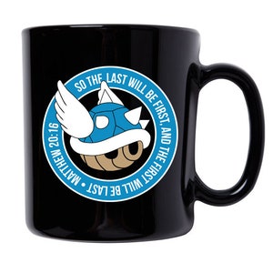 May include: Black ceramic coffee mug with a blue and brown graphic of a winged turtle shell. The graphic is surrounded by a blue circle with the text "So the last will be first, and the first will be last. Matthew 20:16"