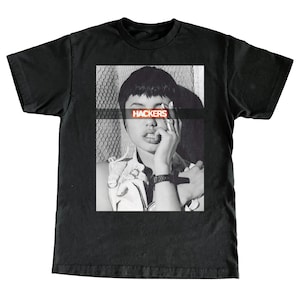 May include: Black and white photo of a person with short hair wearing a leather jacket. The word "HACKERS" is printed in red across the person's eyes.