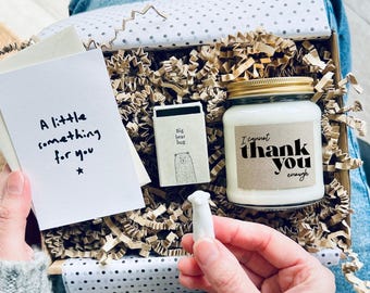 May include: A gift box containing a white candle with a gold lid, a small matchbox with a bear illustration, a card that reads "A little something for you", and a small white bear figurine. The candle label says "I cannot thank you enough".
