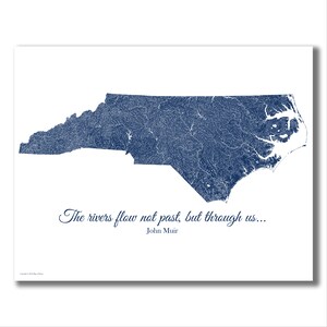 May include: A blue and white print of the state of North Carolina with all the rivers and streams outlined in blue. The quote "The rivers flow not past, but through us... John Muir" is printed below the map.