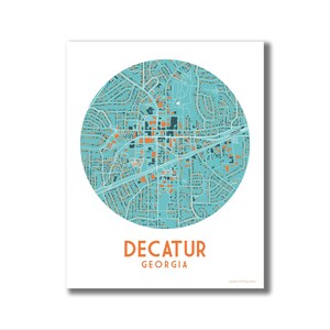 May include: A turquoise and orange map of Decatur, Georgia, with the city name and state printed below the map.