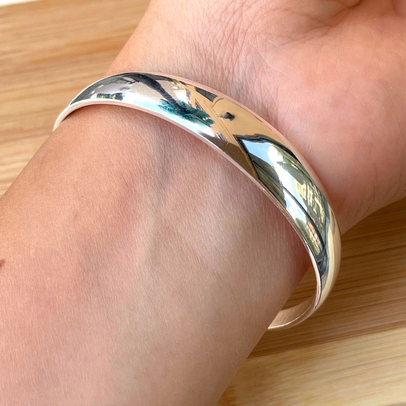 May include: A silver bangle bracelet with a smooth, polished finish.