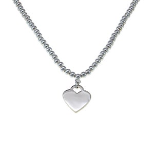 May include: A silver necklace with a heart-shaped pendant.