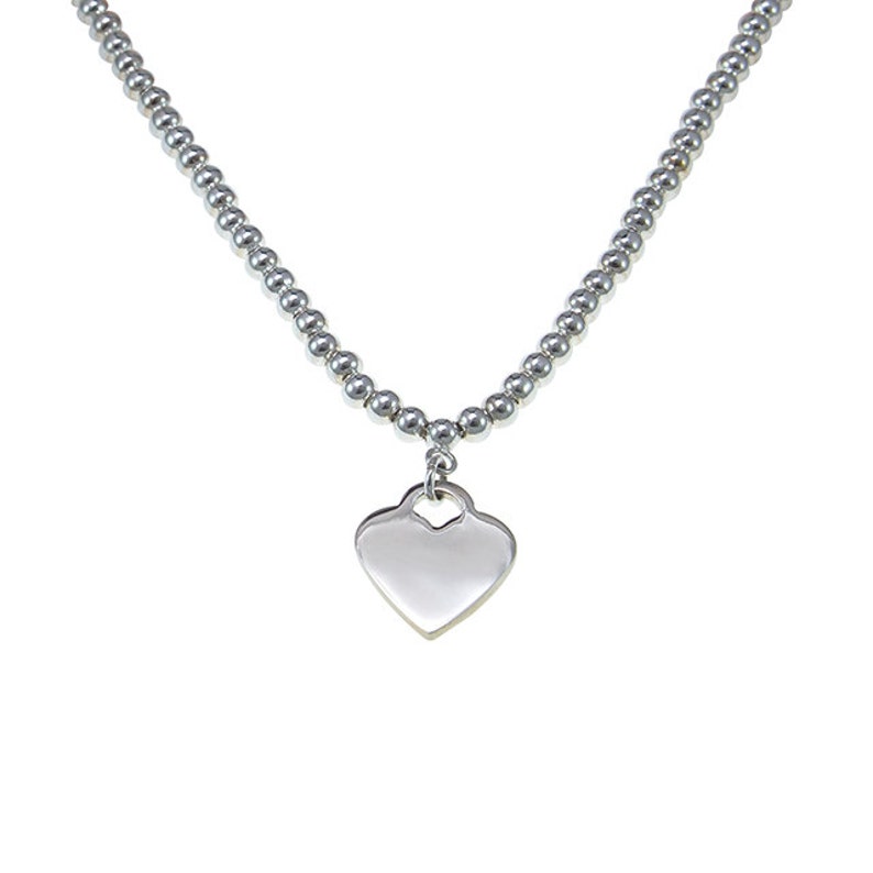 May include: A silver necklace with a heart-shaped pendant.