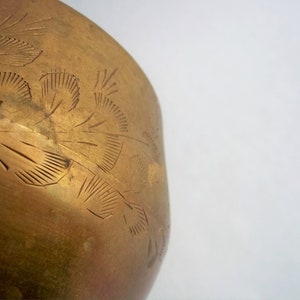 A 12" tall brass goblet.
This is a vintage brass goblet with a leaf etched design around the bowl and the base. 
The bottom of the goblet bowl is not smooth and the bottom goes into the stem a little bit so it's not recommended to drink out of it. 
Great for many styles of décor such as bohemian, farmhouse, romantic or cottage.  
approx. 
12" Tall
4 1/2-3/4" at widest point
3 3/4" opening
4 1/2" depth
base is 4 3/4" diameter
3/8" width at middle of stem
India is etched on bottom