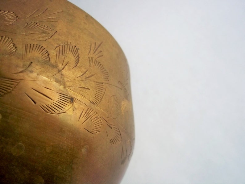 A 12" tall brass goblet.
This is a vintage brass goblet with a leaf etched design around the bowl and the base. 
The bottom of the goblet bowl is not smooth and the bottom goes into the stem a little bit so it's not recommended to drink out of it. 
Great for many styles of décor such as bohemian, farmhouse, romantic or cottage.  
approx. 
12" Tall
4 1/2-3/4" at widest point
3 3/4" opening
4 1/2" depth
base is 4 3/4" diameter
3/8" width at middle of stem
India is etched on bottom