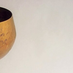 A 12" tall brass goblet.
This is a vintage brass goblet with a leaf etched design around the bowl and the base. 
The bottom of the goblet bowl is not smooth and the bottom goes into the stem a little bit so it's not recommended to drink out of it. 
Great for many styles of décor such as bohemian, farmhouse, romantic or cottage.  
approx. 
12" Tall
4 1/2-3/4" at widest point
3 3/4" opening
4 1/2" depth
base is 4 3/4" diameter
3/8" width at middle of stem
India is etched on bottom