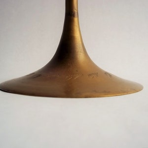 A 12" tall brass goblet.
This is a vintage brass goblet with a leaf etched design around the bowl and the base. 
The bottom of the goblet bowl is not smooth and the bottom goes into the stem a little bit so it's not recommended to drink out of it. 
Great for many styles of décor such as bohemian, farmhouse, romantic or cottage.  
approx. 
12" Tall
4 1/2-3/4" at widest point
3 3/4" opening
4 1/2" depth
base is 4 3/4" diameter
3/8" width at middle of stem
India is etched on bottom