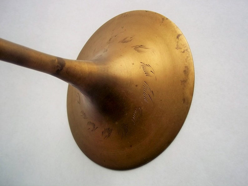 A 12" tall brass goblet.
This is a vintage brass goblet with a leaf etched design around the bowl and the base. 
The bottom of the goblet bowl is not smooth and the bottom goes into the stem a little bit so it's not recommended to drink out of it. 
Great for many styles of décor such as bohemian, farmhouse, romantic or cottage.  
approx. 
12" Tall
4 1/2-3/4" at widest point
3 3/4" opening
4 1/2" depth
base is 4 3/4" diameter
3/8" width at middle of stem
India is etched on bottom