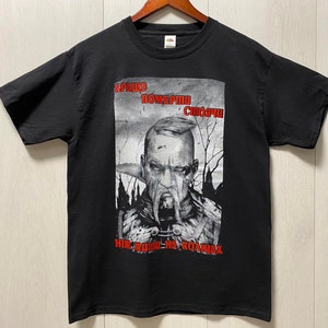 Może przedstawiać: Czarny T-shirt z nadrukiem graficznym przedstawiającym mężczyznę z brodą i wąsami. Tekst na koszulce brzmi "KPAИHE ПOMEPTИ СЛОЖHA НИК-РОДИ-НА-РОДИНА".