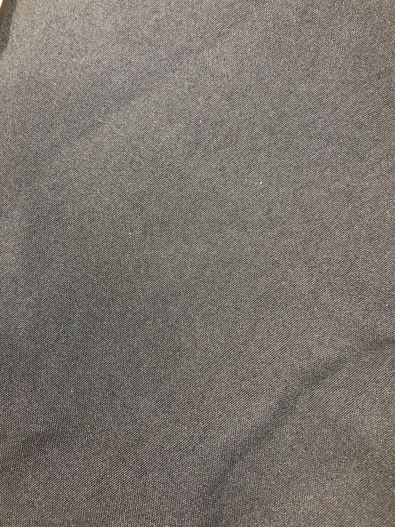 Op de afbeelding: Close-up van een donkergrijze stof met een subtiele geweven textuur.