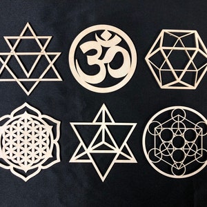 May include: Six wooden geometric shapes, including a flower of life, a star of david, a sacred geometry symbol, and an om symbol. The shapes are all cut from wood and have a natural finish.