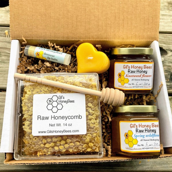 Honeycomb gift box with raw varietal honey jars, pure beeswax candle, handcrafted beeswax lip balm, and wooden honey dipper