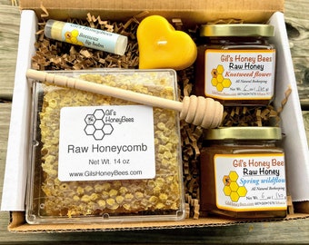 Honeycomb gift box with raw varietal honey jars, pure beeswax candle, handcrafted beeswax lip balm, and wooden honey dipper