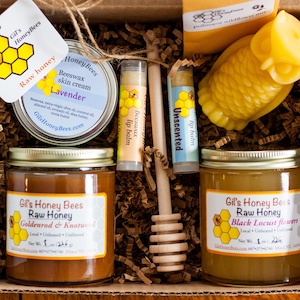 Raw honey gift basket with a beeswax candle, natural skin salve, 2 lip balms. wooden honey dipper, and a bag of pollinators wildflower seed mix