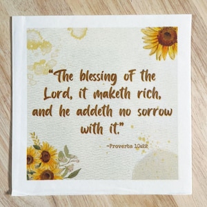 Puede incluir: Un cuadrado blanco con la cita "The blessing of the Lord, it maketh rich, and he addeth no sorrow with it." en texto marrón, de Proverbios 10:22. El cuadrado está decorado con girasoles de acuarela.