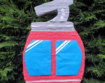 Puede incluir: Piñata roja y azul con forma de teleférico con techo gris y cuerda amarilla.