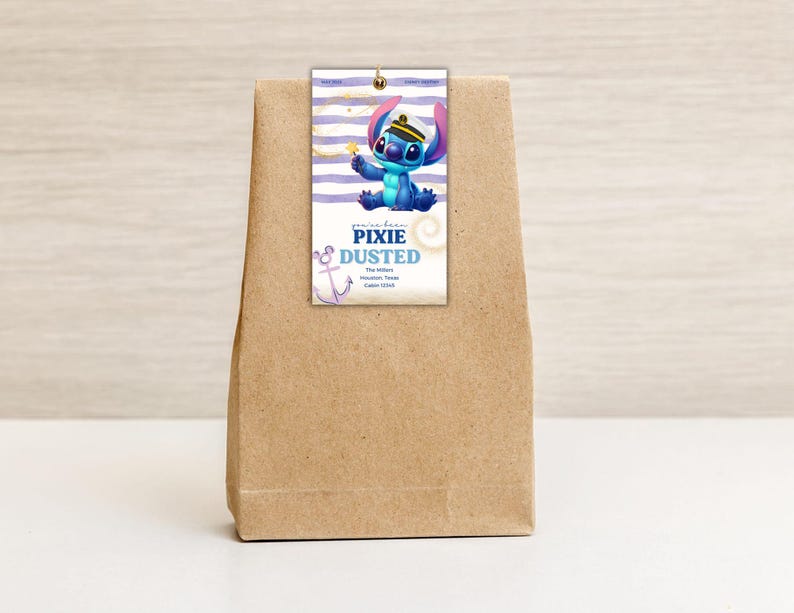 May include: A brown paper bag with a tag featuring a blue cartoon character wearing a sailor hat. The tag has the words "Pixie Dusted" and an anchor graphic. The background of the tag has white and purple stripes.