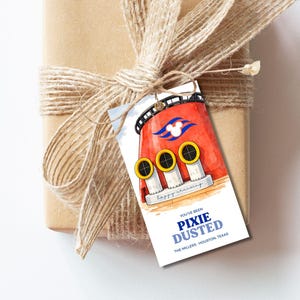 Può includere: Un regalo avvolto in carta marrone e legato con spago, con un'etichetta regalo personalizzata. L'etichetta presenta un'illustrazione ad acquerello di una nave rossa con oblò gialli e il testo "You've been Pixie Dusted".