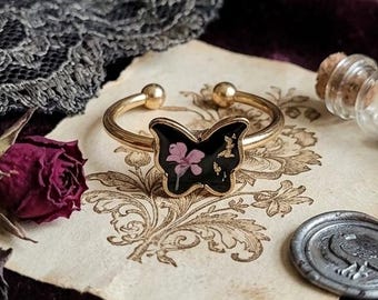 Butterfly ring, with real flowers, in steel.