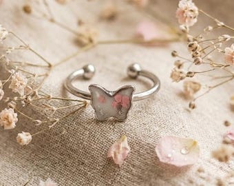 Butterfly ring, with real flowers, in steel.