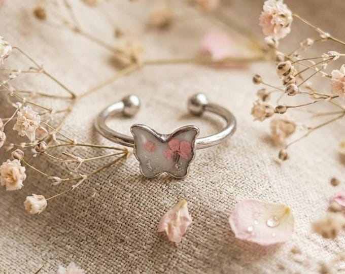 Butterfly ring, with real flowers, in steel.