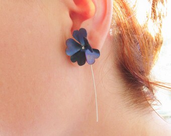 May include: A pair of earrings featuring a dark blue flower design with a silver stem.