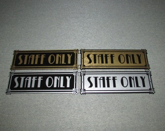 May include: Four metal signs with the text "STAFF ONLY" in gold and black lettering on a black, gold, and silver background.