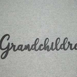 May include: Black metal sign with the word "Grandchildren" in a cursive font. The sign is displayed against a light gray textured background. This decorative sign is suitable for home decor.