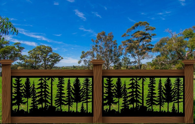May include: A wooden fence with a decorative black metal panel featuring a silhouette of a forest scene. The fence is brown with a natural wood grain, set against a backdrop of green grass and a blue sky with clouds.
