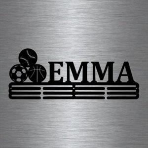May include: Black metal medal display rack with the name "EMMA" and a stack of three sports balls: a soccer ball, a basketball, and a baseball.