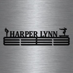 May include: Black metal medal display rack with the name "HARPER LYNN" and two gymnast silhouettes. The rack has five horizontal bars for hanging medals.