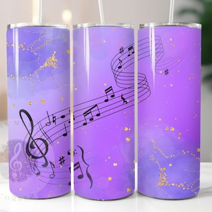 May include: Three purple and gold stainless steel tumblers with a musical note design. The tumblers have a gradient of purple and gold glitter. The musical notes are black and are in a flowing design.
