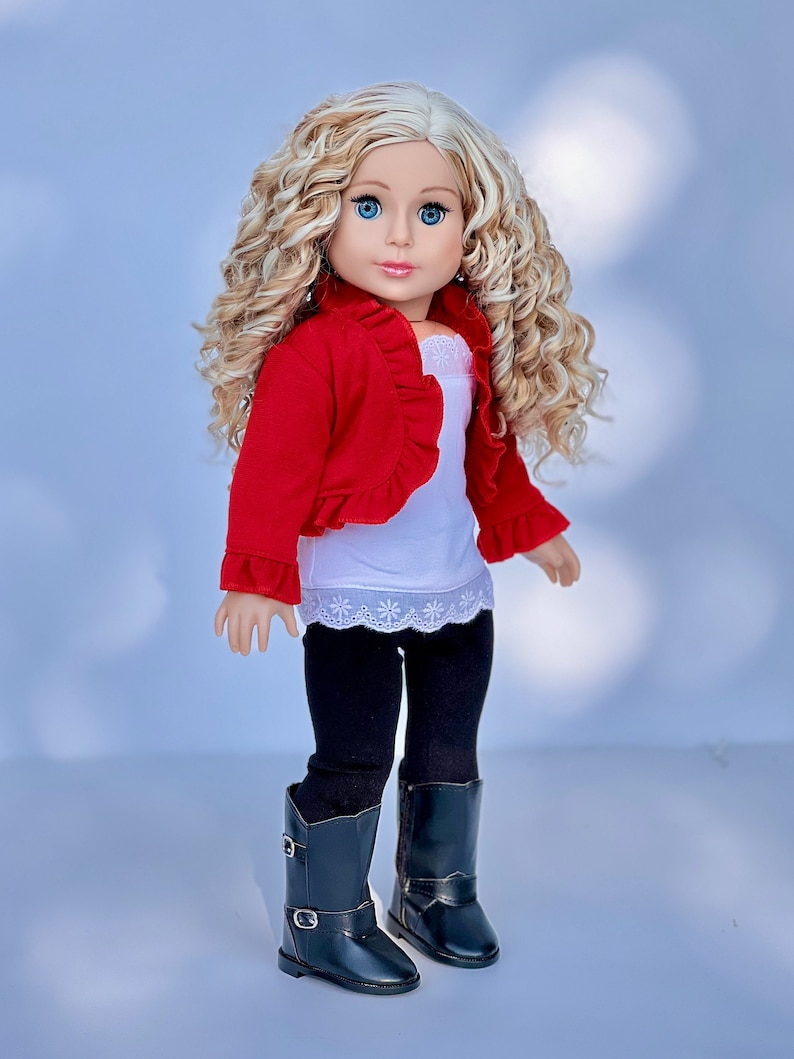May include: A doll with long blonde curly hair wearing a red ruffled cardigan, a white tank top with lace trim, black leggings, and black riding boots.