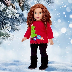 May include: A red doll wearing a Christmas sweater with a green tree and presents on it. The doll has long curly red hair and is wearing black pants and black boots.