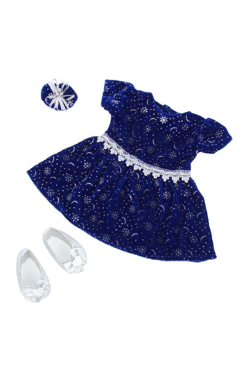 K&ouml;nnte beinhalten: Ein blaues Samtkleid mit silbernem Glitzer und einer wei&szlig;en Spitzenborte. Das Kleid wird mit einem passenden silbernen Stirnband und einem Paar silberner Schuhe geliefert.