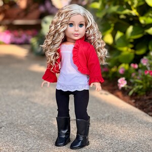 May include: A doll with long blonde curly hair wearing a red ruffled jacket, a white tank top with lace trim, black leggings, and black boots.