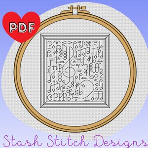 May include: A black and white cross stitch pattern of musical notes and symbols in a wooden embroidery hoop. The pattern is titled "Stash Stitch Designs".