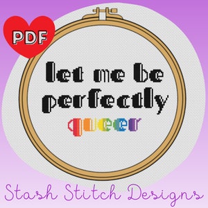 May include: A cross stitch pattern in a wooden embroidery hoop with the text "Let me be perfectly queer" in black text and the word "queer" in rainbow colors.